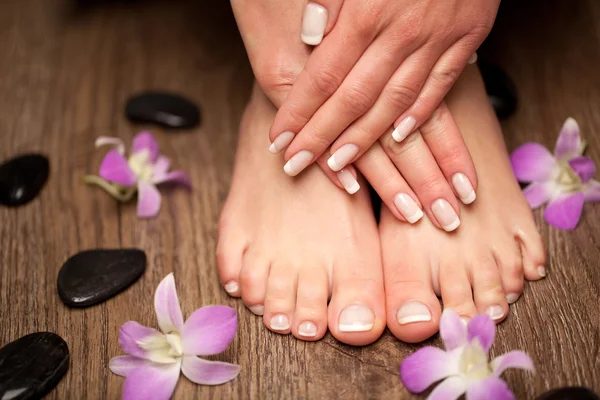 Fresh manicure and pedicure with orchid petals